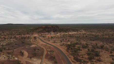 drone ascending over a remote bushland revealing a hill and lookout in australia
