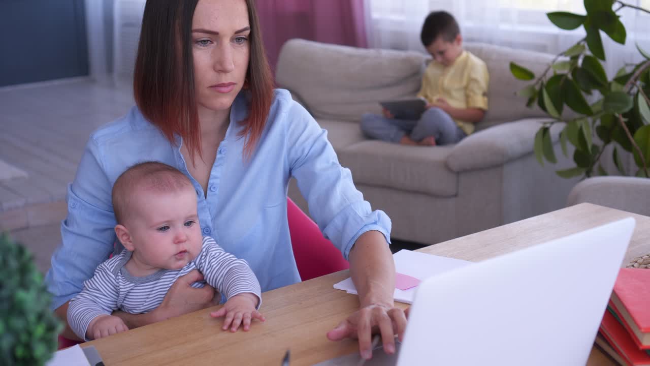 아이들과 함께 노트북에서 일하는 어머니