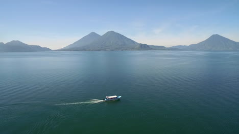 aerial over a boat on lake amatitlan in guatemala reveals the pacaya volcano in the distance 2