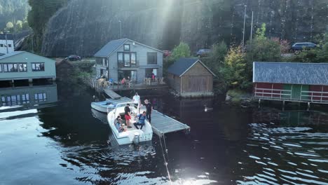 boat arrives at a dock with passengers preparing to exit, sunlight reflecting on water surface