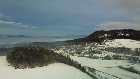 Toma-Aérea-De-Un-Pueblo-De-Montaña-Cubierto-De-Nieve-En-La-Niebla