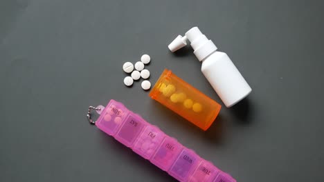 medical pills , pill box and spray on table ,