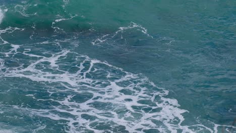 big ocean swell and rushing white wash wave in beautiful turquoise ocean water in the wilderness of new zealand aotearoa