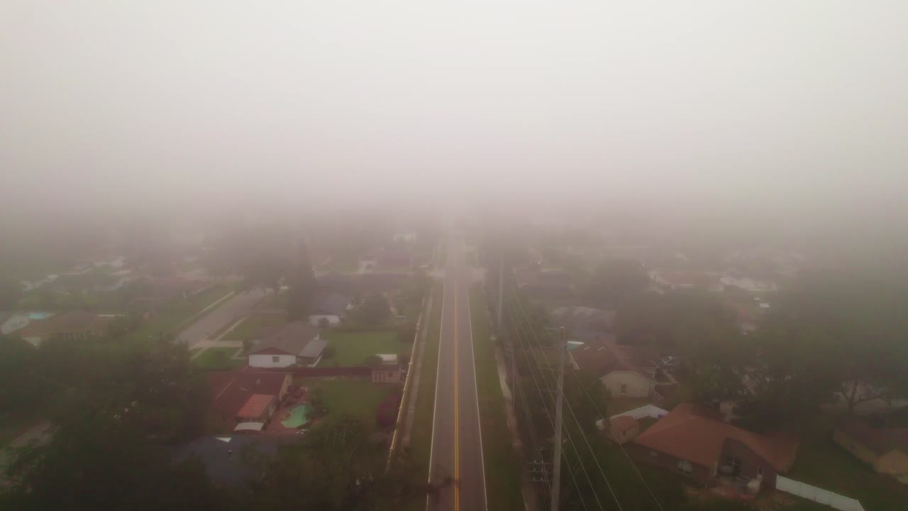 차량 운전 없이 플로리다 주 오코이 시를 통과하는 안개 낀 도로의 공중 비행