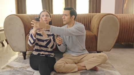 marido y esposa indios luchando por el control remoto de la televisión