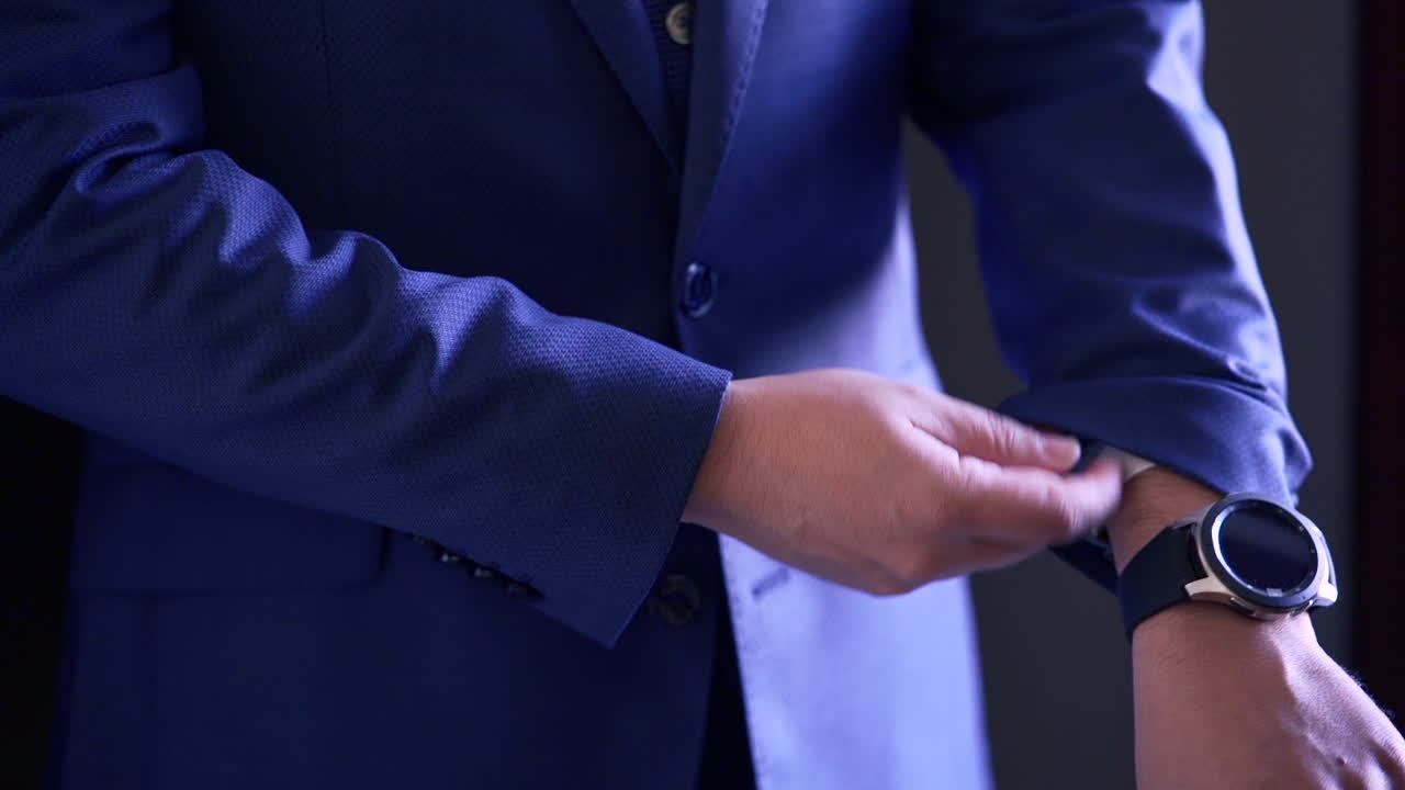 Man buttoning his blue suit jacket