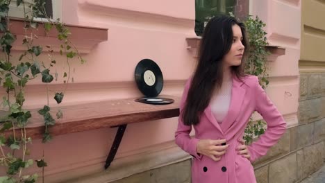 wonderful brunette posing on the street near a music store