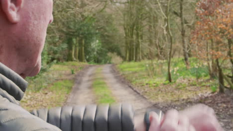 close up of senior man running in countryside exercising checking smart watch fitness activity app