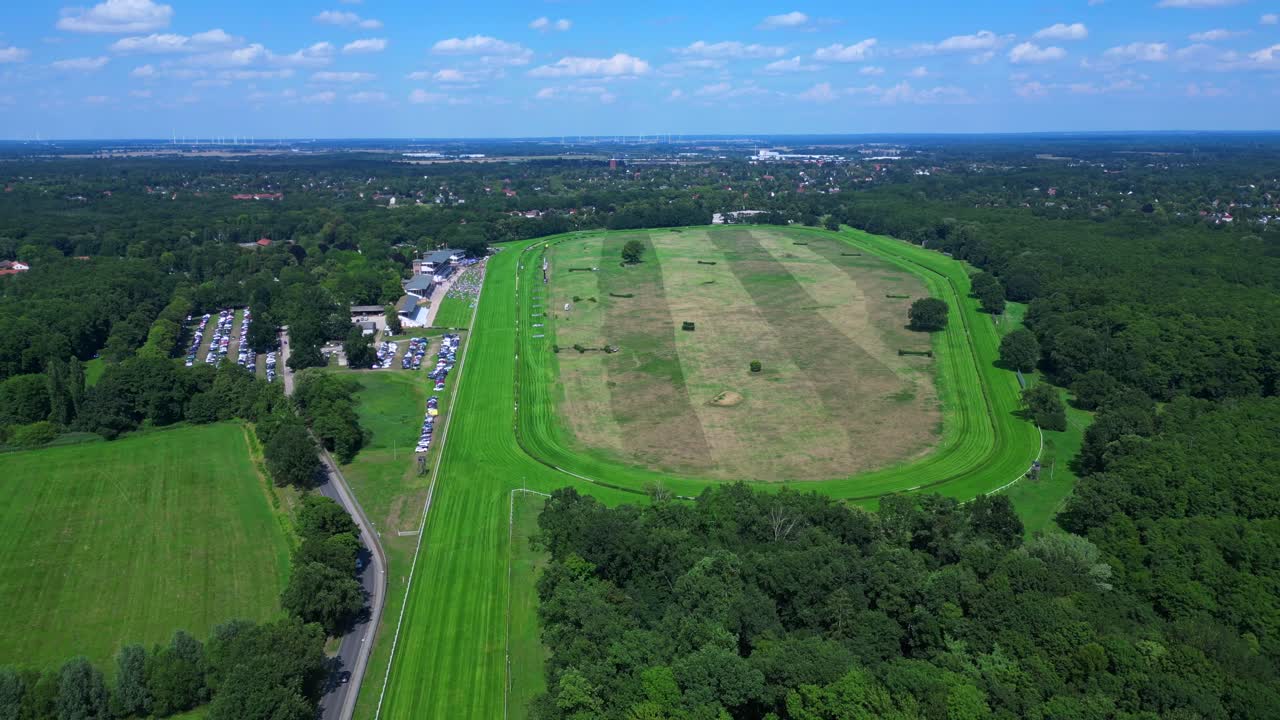 Horse gallop racecourse near a forest in Germany, parking lot visible. Nice aerial view flight fly reverse drone