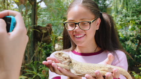 Iguana,-friends-and-phone-with-girl-in-zoo