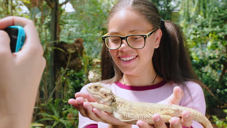 iguana, amigos y teléfono con la chica en el zoológico