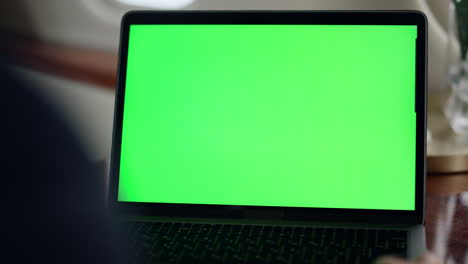 en primer plano, la mano agita la pantalla verde de la computadora portátil. gerente de videollamadas chroma clave socio