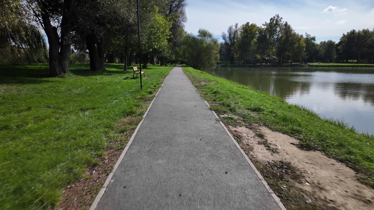Pathway along lake in green park