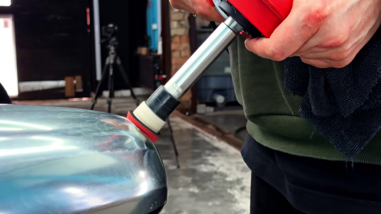 Close-up Of Hand Using Small Rotary Polisher On Dull, Silver Side-View Mirror.