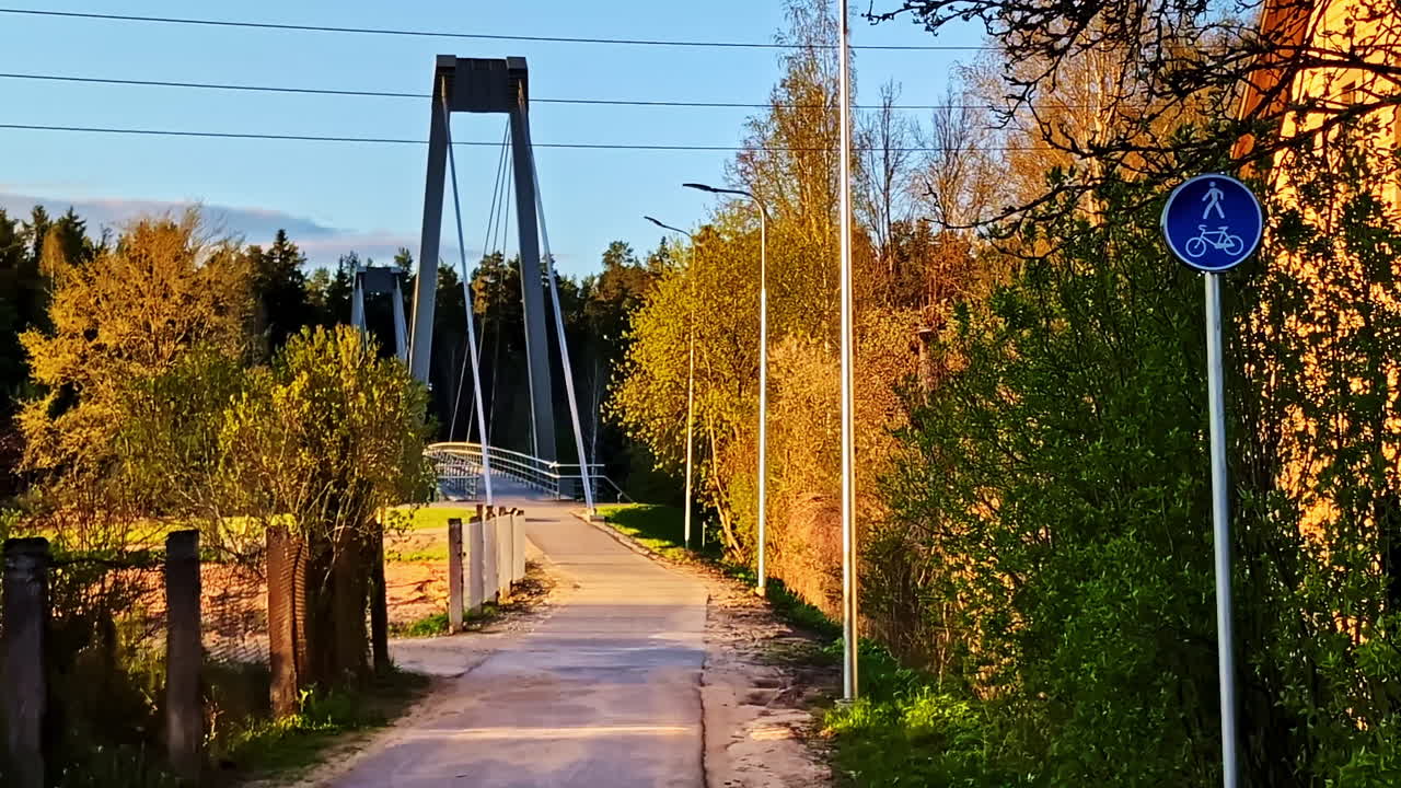 Pathway leading to pedestrian bridge in Valmiera, Latvia during golden hour