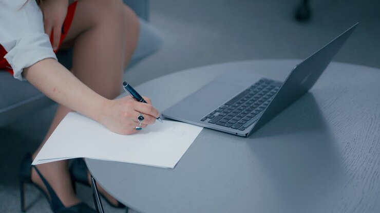 Primo piano della mano di una donna che scrive informazioni su un foglio al rallentatore.