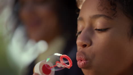 Dreamy-girl-blowing-soap-bubbles-closeup.-Joyful-kid-enjoying-family-picnic.