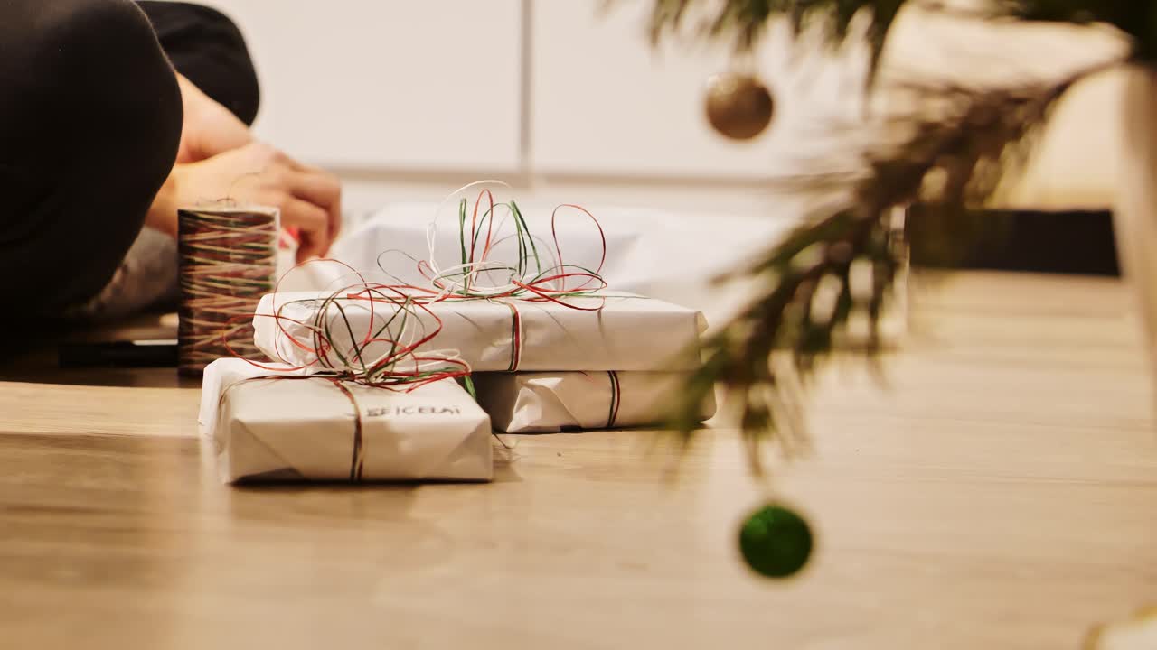 Warm festive scene showing Christmas presents being wrapped in cozy home light