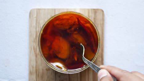 homemade mango pickle in a glass jar on table