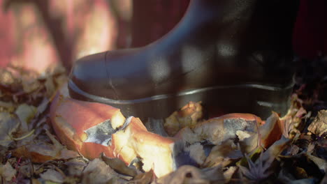 decaying halloween jack-o'-lantern smashed by a black boot