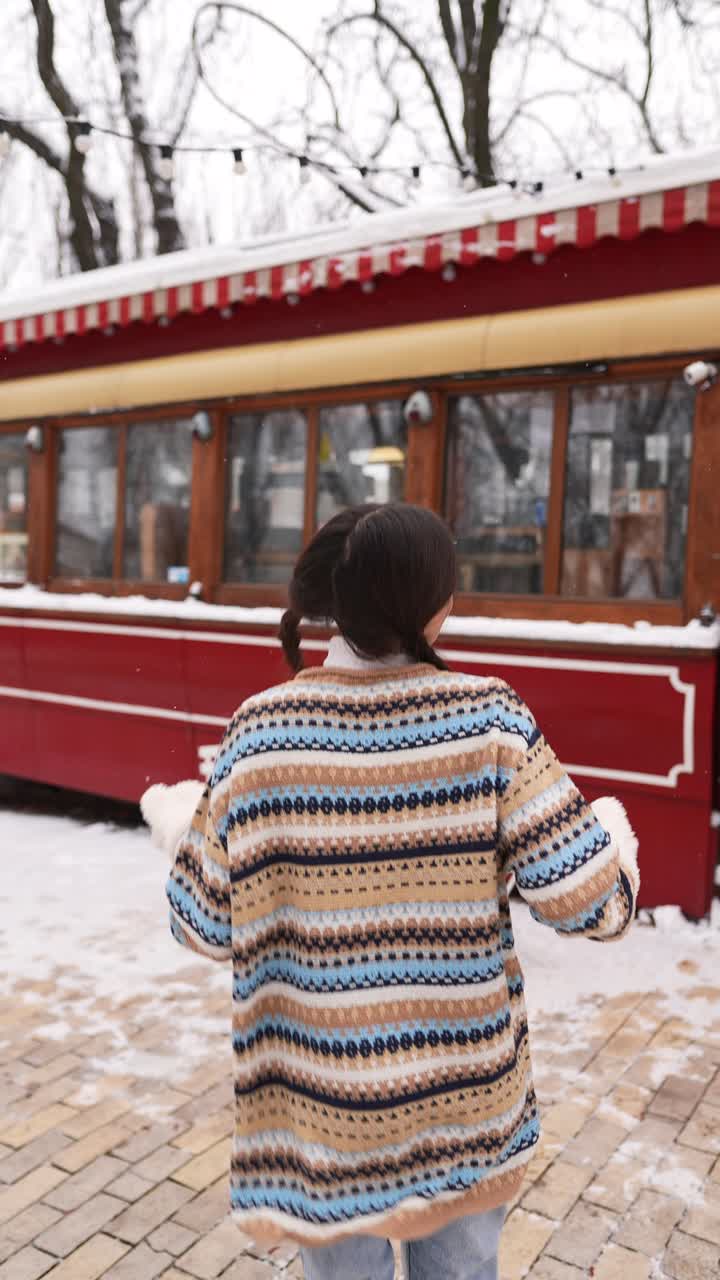 joven disfrutando de la nieve fuera de un café