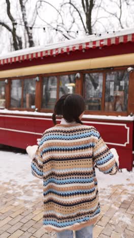 young woman enjoying the snow outside a cafe