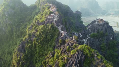 aerial drone circling around a big limestone mountain with a dragon temple in vietnam