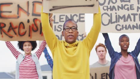 Diverse-group-of-protesters-holding-cardboard-banners-and-screaming