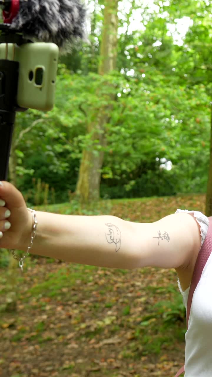 Woman with arm tattoos in a forest setting