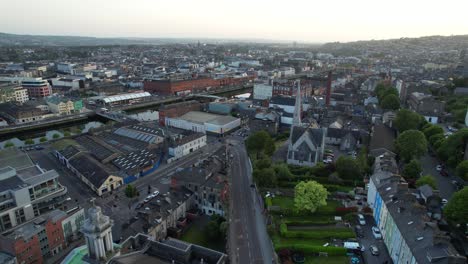 Aerial-pull-back-of-Cork-city-at-sunset-revealing-colorful-houses,-Ireland