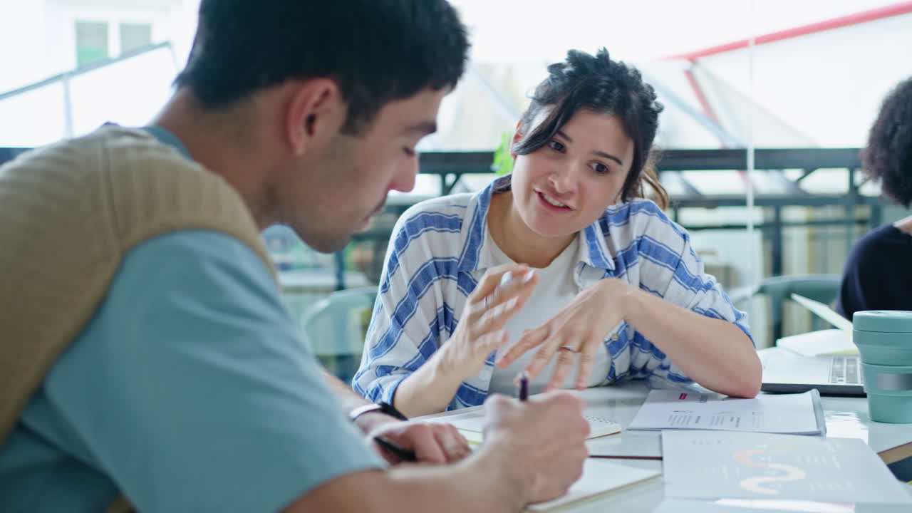 Joven empresaria afroamericana hablando con su equipo en una moderna sala de coworking