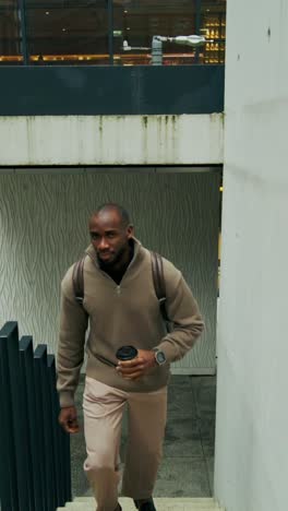 man walking up stairs in a modern city building