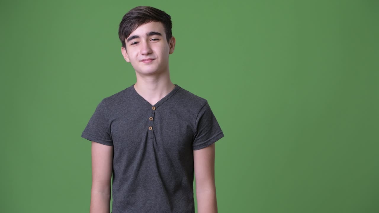 joven y guapo adolescente iraní contra un fondo verde