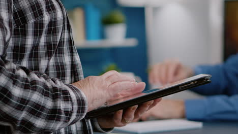 primer plano de las manos de la mujer sosteniendo la tableta de pie en el lugar de trabajo