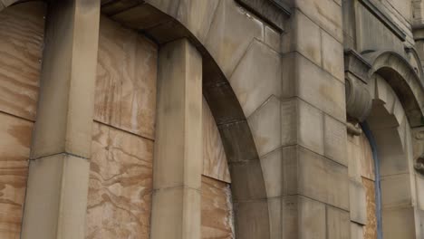 Stone-building-with-boarded-up-windows-medium-panning-shot