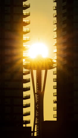 vertical timelapse footage of the space needle perfectly aligned with the setting sun during a stunning summer sunset.