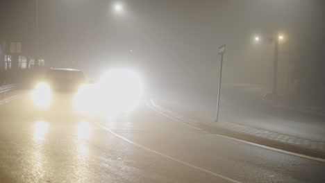 coches veloces con faros desenfocados viajan por la carretera de la ciudad por la noche