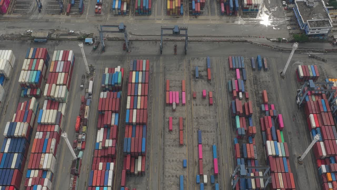 Aerial view of busy industrial port with cargo ships, cranes and containers