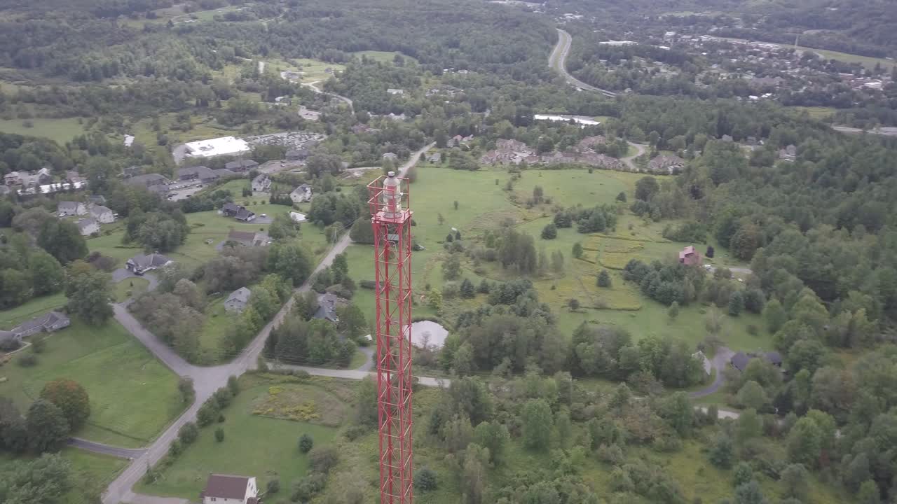Drone aerial rotating view around a radio tower several hundred feet tall in the heart of the green mountains