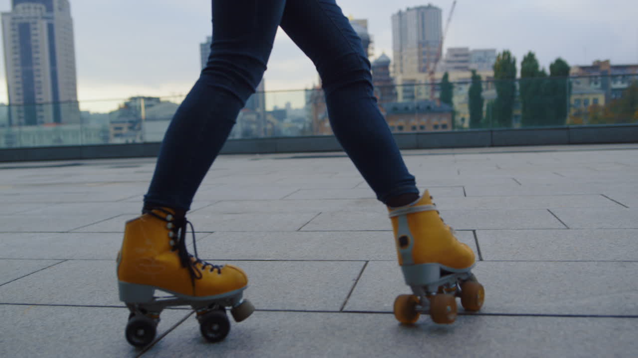 Gadis hipster menari di luar ruangan dengan sepatu roda. Wanita menari di atas sepatu roda.