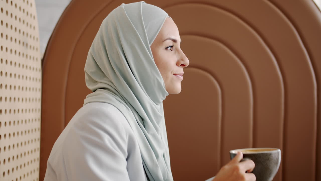 Woman in Hijab Drinking Coffee in a Cafe