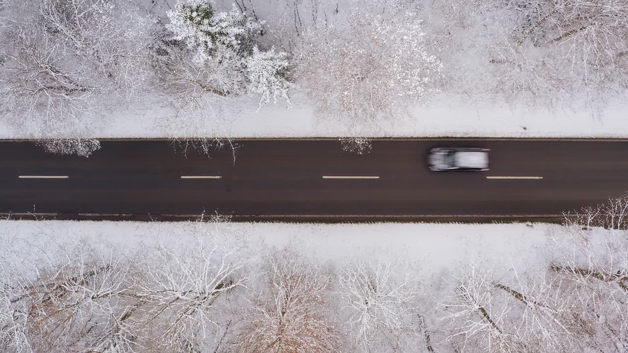 el coche de arriba conduce rápido por una carretera invernal con nieve en el techo