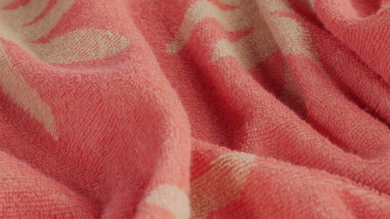 Primo piano macro della trama di un tessuto di colore rosa. Stampa floreale. Tessuto moda multicolore. Filmato 4K di alta qualità