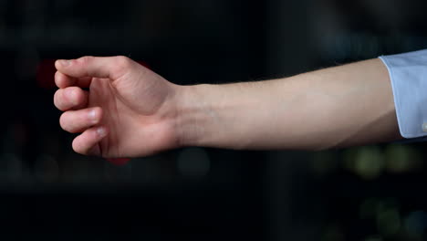 macro of man hand rolling sleeve on black background. man hand touching botton