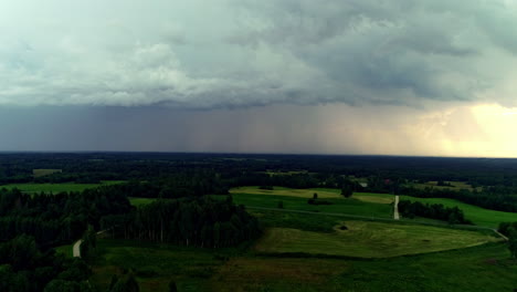 Absteigende-Luftaufnahmen-Einer-Gemischten-Landschaft-Mit-Grünen-Wiesen-Und-Wäldern-Bei-Einbruch-Der-Dunkelheit