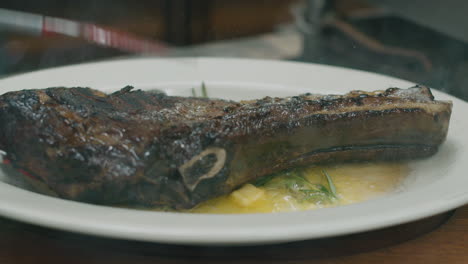 Close-up-on-hot-grilled-dry-Australian-beef-steak-flipped-in-the-plate-with-melted-butter