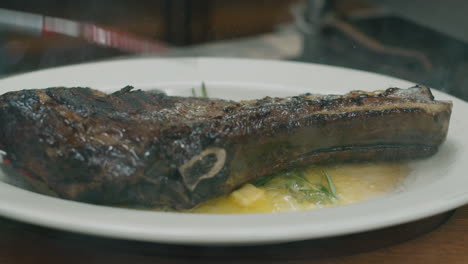 close up on hot grilled dry australian beef steak flipped in the plate with melted butter