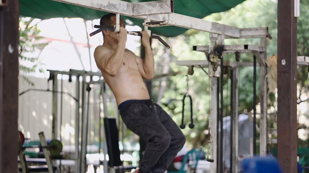 Man exercising with pull-ups at an outdoor gym