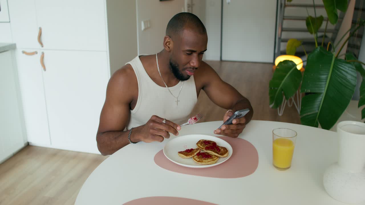 un hombre tomando una foto de su desayuno con su teléfono.