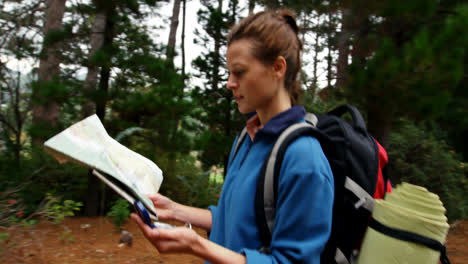 vista lateral de un excursionista caminando con un mapa y una brújula